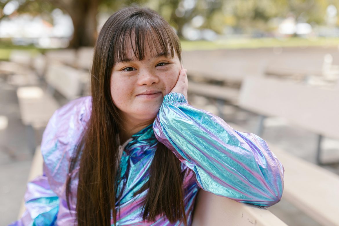 smiling girl with Down syndrome sitting on a bench